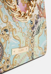 Bolso de mano con un exterior sintético estampado en colores pastel, que cuenta con una correa de cadena en tono dorado y una placa metálica con el logotipo de la marca.