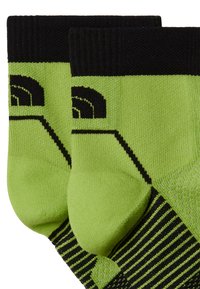Los calcetines verdes y negros presentan un diseño texturizado con patrones a rayas. La punta y el talón son de un verde sólido con un acento gráfico negro.