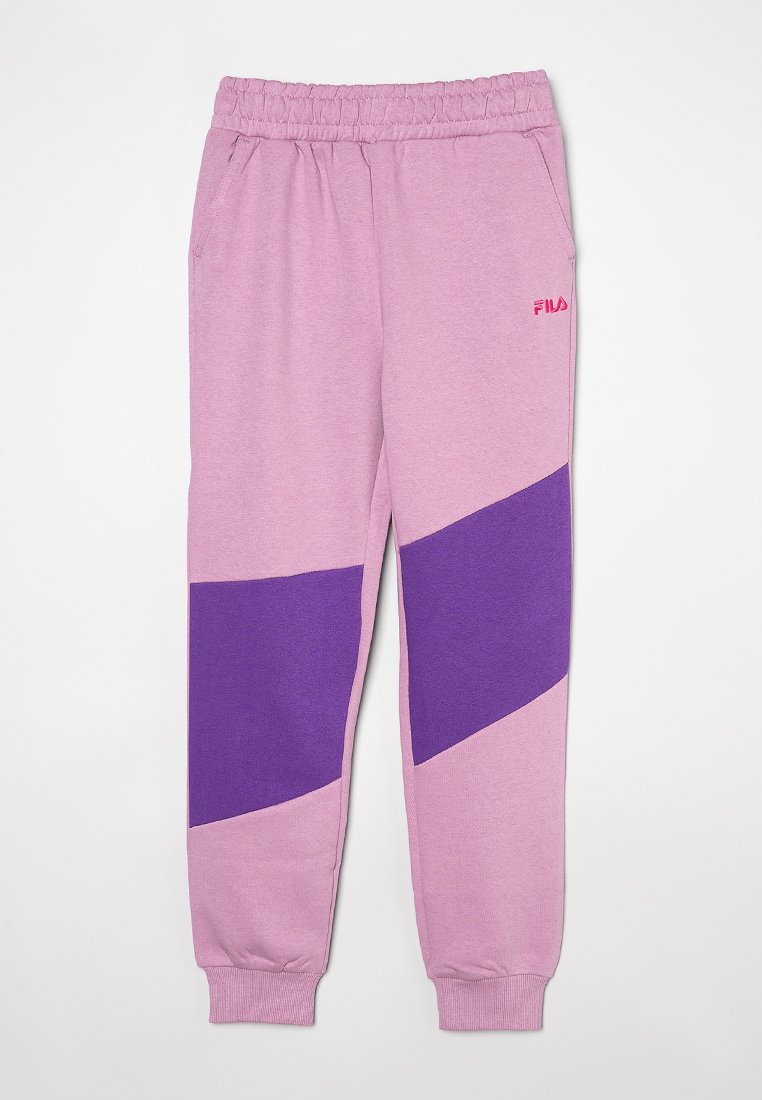 Pantalon de survêtement rose clair avec un panneau diagonal violet et une taille élastique. Présente le logo FILA en rose sur la cuisse gauche. Texture douce.