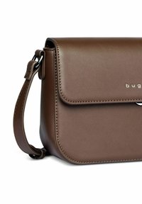 Borsa a spalla in pelle sintetica marrone con chiusura a pattina, hardware argentato e tracolla foderata con cuciture dettagliate.