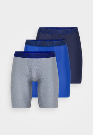 Three pairs of men's boxer briefs: one gray, one blue, one navy. Each features a band with "UNDER ARMOUR" in bold, contrasting text.