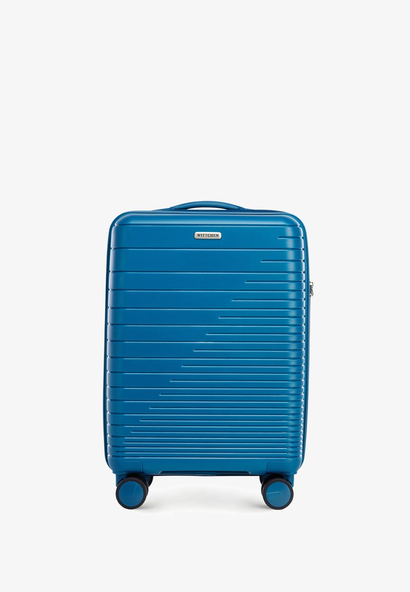 Valise rigide de couleur bleue avec un design à rainures verticales, dotée d'une poignée supérieure, d'une fermeture éclair et de quatre roues noires pour la mobilité.