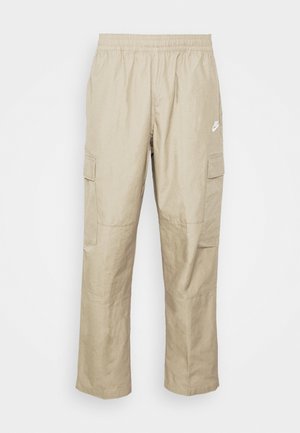 Pantaloni cargo beige con una cintura elastica, gambe taperate, molteplici tasche laterali e un piccolo logo bianco nella parte anteriore. Tessuto leggero.