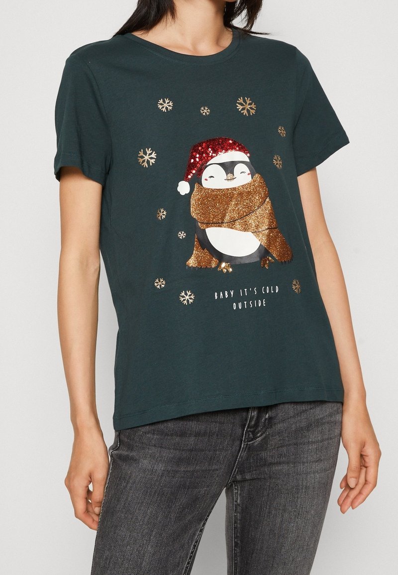 Camiseta de manga corta verde oscuro con un pingüino brillante que lleva una bufanda y un sombrero festivo, con acentos de copos de nieve y texto abajo.