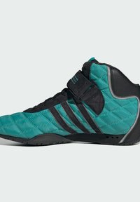Høje sneakers med en kviltet teal overdel og sorte accenter, justerbar velcrorem og tekstureret sort sål.
