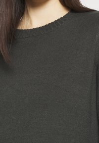 Dark green knit sweater with a round ribbed neckline and a soft texture. The fabric features a subtle horizontal pattern.