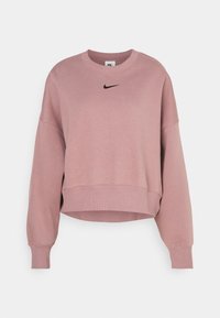 Sweat-shirt Nike court rose à col rond avec manches longues et logo Nike Swoosh noir centré sous le col.