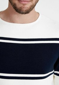 Weißer Pullover mit dunkelblauen horizontalen Streifen, mit einem gerippten Muster und einem Rundhalsausschnitt. Keine auffälligen Beschläge oder Muster.