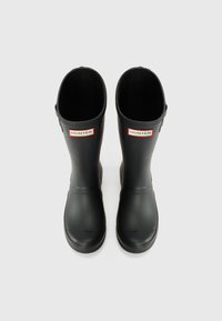 Schwarze Gummiregenstiefel mit runder Zehenform, glatter Textur und einem Logo-Patch auf der Vorderseite. Langer Schaft ohne sichtbare Beschläge oder Akzente.