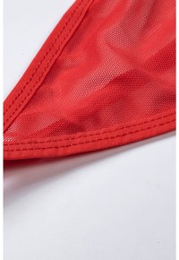 Red mesh fabric with a smooth edge, featuring textured patterns and reinforced stitching along the borders.