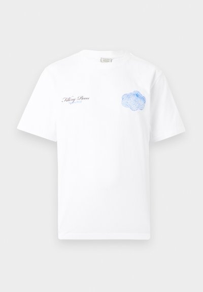 Λευκό κοντομάνικο μπλουζάκι με μικρό μαύρο και μπλε κείμενο "Filling Pieces" στο αριστερό στήθος και μπλε αφηρημένο γραφικό δίχτυ στο δεξί στήθος.