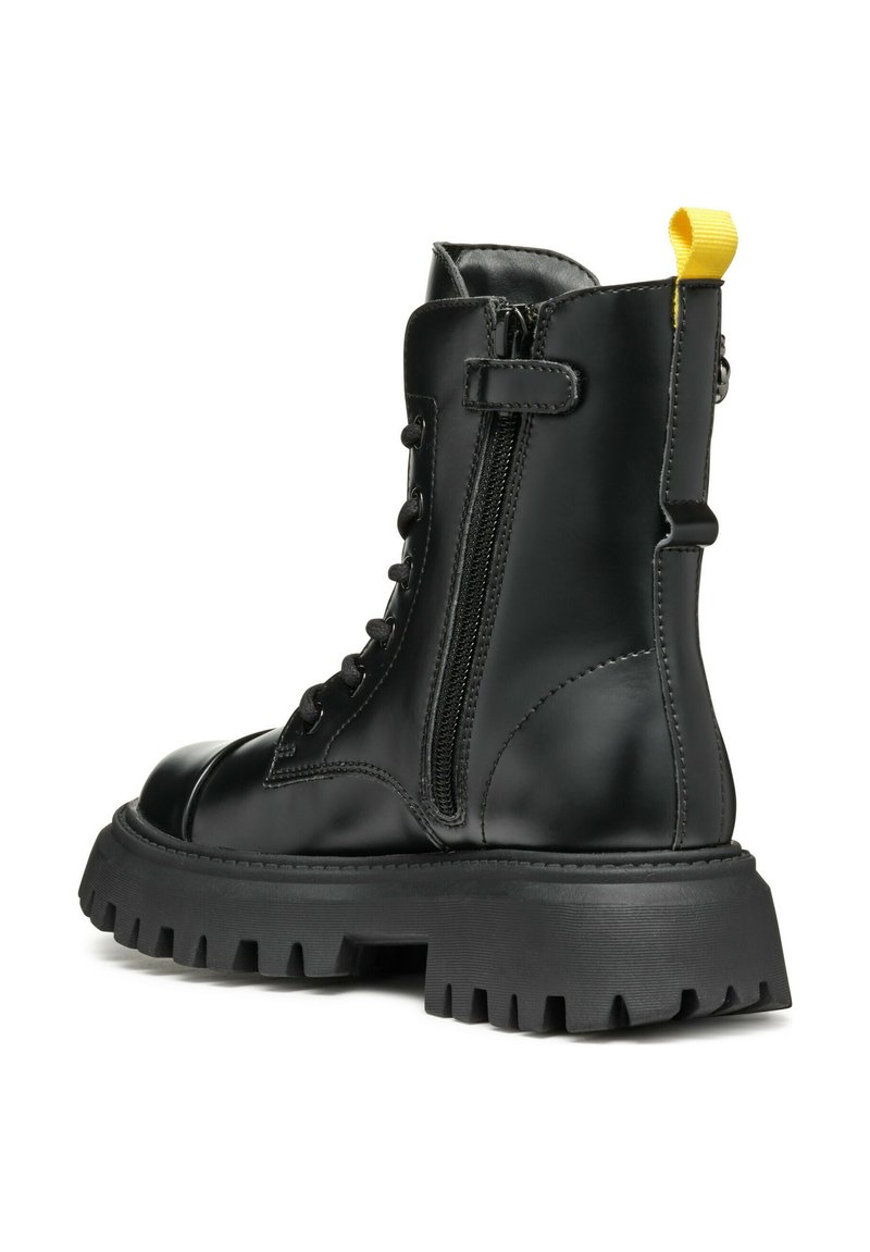 Stivale alla caviglia in pelle nera con suola spessa, cerniera laterale, punta rotonda e un manico giallo. Presenta una chiusura con lacci davanti e suola in gomma testurizzata.