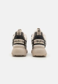 Sorte og beige joggesko med en teksturert pelsforing, kontrasterende skinndetaljer og fremtredende merkebånd bak.