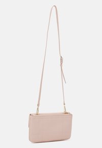 Ljusrosa quiltad crossbody-väska av slätt material, med dragkedjestängning och avtagbar axelrem med guldfärgade detaljer.