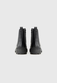 Black leather ankle boots with a textured finish, chunky black sole, and rear zip closure. Features pull tabs for easy wear.