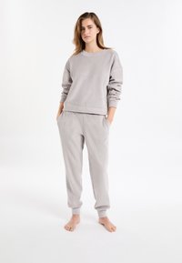 Grijze katoenen sweatshirt met geribbelde structuur en ronde hals, gecombineerd met bijpassende joggerbroek met zijzakken en taps toelopende boorden.