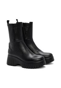 Bottines en cuir noir avec un bout rond, fermeture éclair sur le côté, et une semelle texturée présentant une plateforme épaisse et des rainures profondes.