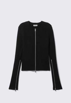 Pull côtelé noir avec un col rond et une fermeture éclair intégrale à l'avant, doté de manches longues avec fermetures éclair aux poignets et d'une coupe courte.