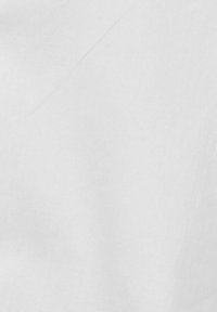 Hvidt stof med en glat tekstur, der har subtile folder og en ensartet farve, hvilket indikerer et let og alsidigt materiale.