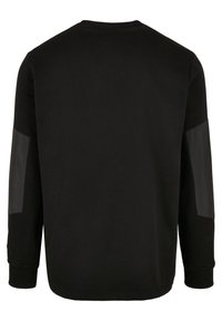 Sweat-shirt noir à manches longues avec poignets côtelés et patchs rectangulaires brillants dans le dos des deux manches.