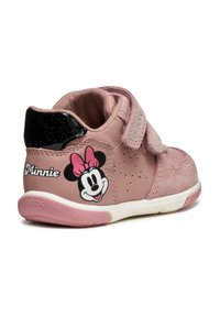 Sneaker rosa realizzato con materiali scamosciati e sintetici, fascia in velcro, lati perforati, tacco glitter nero e grafica di Minnie Mouse con il suo nome.