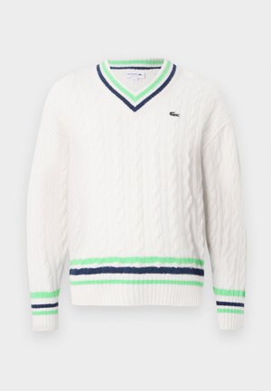 Maglione bianco a maglia con scollatura a V, con strisce verdi e blu navy su collo, polsini e orlo, caratterizzato da un piccolo logo di coccodrillo sul petto.