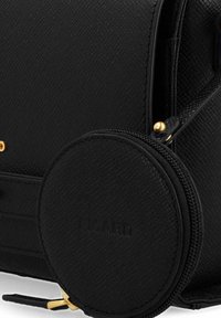 Borsa a tracolla nera con superficie testurizzata e portamonete rotondo con zip, caratterizzato da un accento dorato. Il materiale presenta una superficie a motivo per un tocco aggiuntivo di dettaglio.