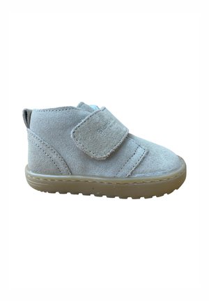 Zapato infantil de ante gris claro con suela de goma y cierre de correa ancha de Velcro sobre fondo blanco.