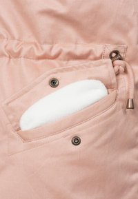 Polstret rosa jakke-lomme med myk hvit fôr, sikret med en bronsefarge knapp og en snøring for lukking.