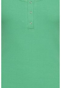 Grøn ribbet tanktop med knaplukning foran og sølvfarvede hardware-detaljer. Stoffet er glat med vertikal struktur.