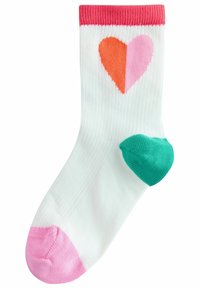 Chaussette blanche côtelée avec un revers rose, ornée d'un motif de cœur divisé en orange et rose, et avec un talon vert et un orteil rose.