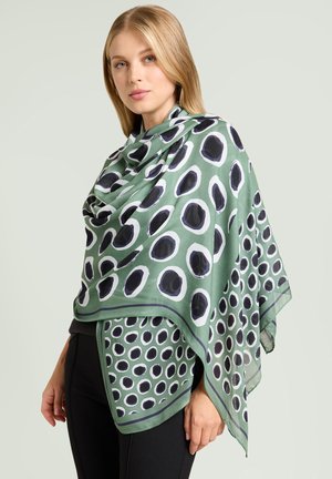 Bufanda verde con un patrón de lunares, con círculos negros y blancos. Tela ligera que cae con estilo, con un borde de contraste.