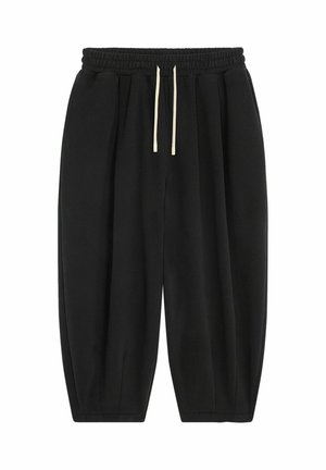 Pantalons de survêtement noirs à coupe ample, avec une taille élastique et des cordons de serrage de couleur claire. Comprend des poches latérales et une texture de tissu douce.