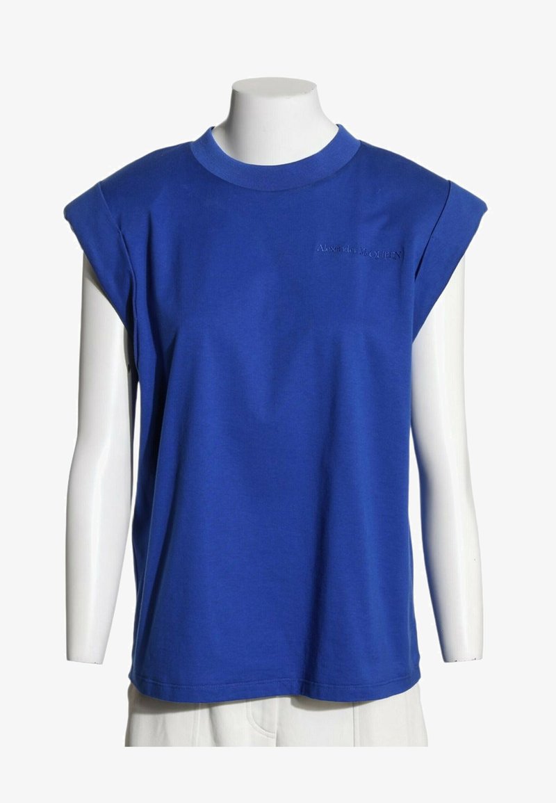 Haut bleu sans manches avec épaules rembourrées et logo brodé subtil sur la poitrine, présenté sur un buste de mannequin blanc.