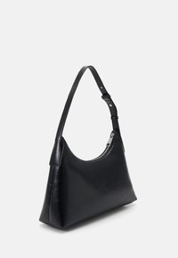 Sac à main en cuir noir avec une forme arrondie, une bandoulière ajustable et une ouverture zippée avec des éléments en métal argenté. Texture lisse avec un minimum de détails.