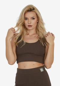 Brązowy prążkowany crop top z okrągłym dekoltem, w połączeniu z pasującymi spodniami o wysokim stanie z małą, wzorzystą metką.