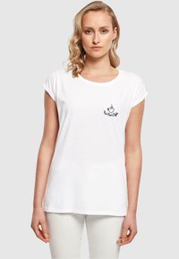Hvid bomuld t-shirt med rulle ærmer, der har et sort kaffekoplogo og teksten "Men først kaffe" på venstre brystområde.