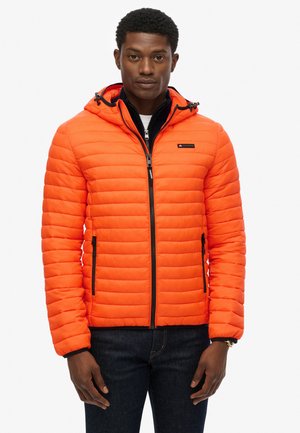 Chaqueta acolchada naranja con capucha, que presenta un cierre de cremallera en la parte delantera, bolsillos laterales, detalles en negro y un diseño de acolchado horizontal.