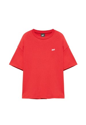 T-shirt oversize rossa a maniche corte con piccolo logo bianco sul petto sinistro e scollatura tonda.