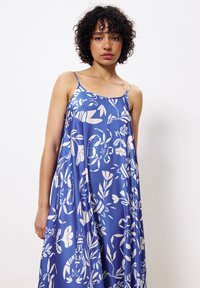 Blauwe mouwloze jurk met een wit bloemdessin en kreeftenpatroon, gemaakt van een gladde stof, heeft een relaxte pasvorm en spaghettibandjes.