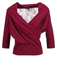 Blouse bordeaux manches longues style cache-cœur avec une insertion en dentelle florale au profond décolleté en V et des poignets côtelés.