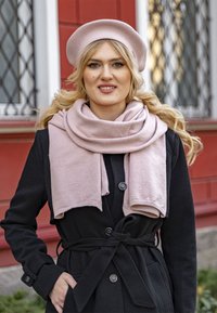 Fekete kabát, derékra kötős fazonnal, texturált anyagból készült, gombokkal díszítve, világos rózsaszín kötött sállal és hozzá illő beretth添加ye.