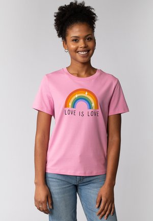 T-shirt en coton rose avec un graphique arc-en-ciel et le texte "L'AMOUR EST L'AMOUR" en dessous. Manches courtes et encolure ronde.