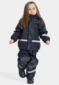 Marineblauer wasserdichter Anzug und Hose mit reflektierenden Streifen. Die Jacke hat elastische Bündchen und eine Kapuze; die Hose weist strukturierte Akzente und einen elastischen Bund auf.