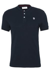 Polo bleu marine avec un col henley, trois boutons blancs et un petit logo brodé sur la poitrine gauche. Texture de tissu lisse.