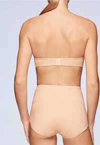 Bikini set sadrži bešavni goli bandeau top i donji deo visokog struka. Izrađen od glatkog materijala s minimalnim elastičnim dizajnom.