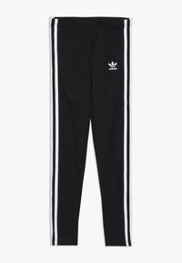 Leggings noirs en tissu extensible avec des rayures latérales blanches et un petit logo blanc à l'avant. Ajustés et texture lisse.