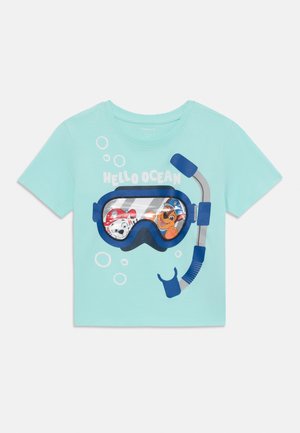 Egy világoskék gyerekpóló, melyen búvárszemüveg és légzőcső grafikája látható, tele mesefigurákkal és buborékokkal.