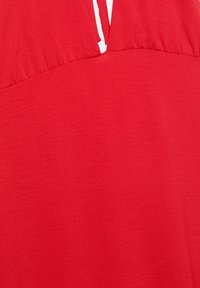 Rotes, ärmelloses Kleid aus strukturiertem Stoff mit einem V-Ausschnitt und gerafftem Detail an der Brust. Glattes, leichtes Material.