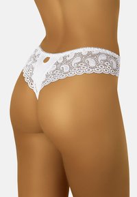 Weiße Spitzenunterhose mit floralen Mustern, gewellten Kanten und einem Schlüssellochdetail auf der Rückseite, das eine zarte, weiche Textur zeigt.
